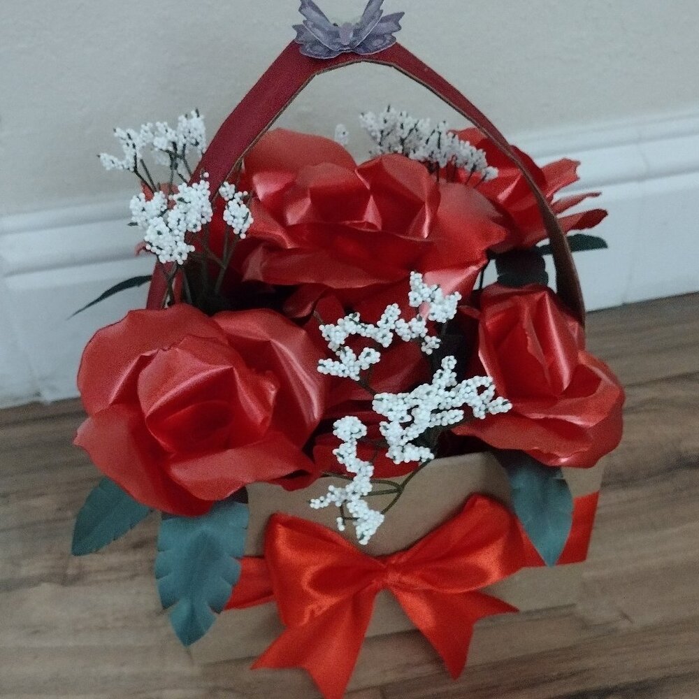 Handmade floral arrangement with plastic ribbon roses.